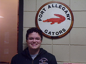 Mikya Stake standing next to Port Allegany Gators logo