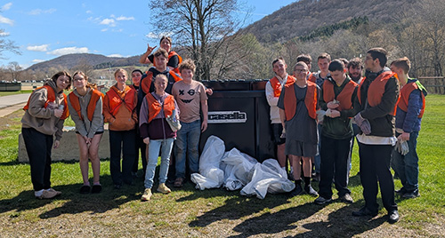 Group of happy students meeting up for Earth Day community service