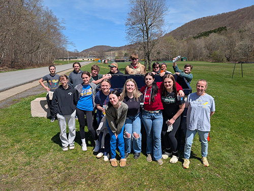Group of happy students posing for a photo during community service