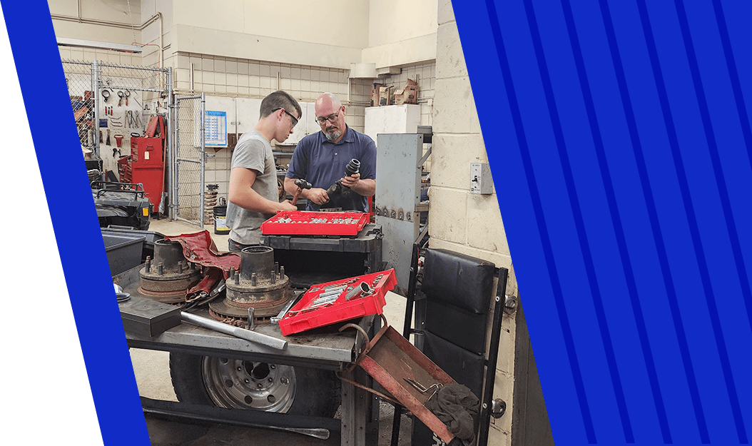 Student working with instructor in garage classroom