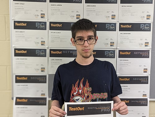 student proudly holding his certificate