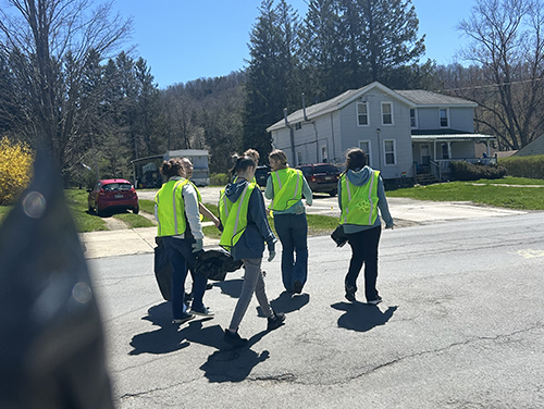 Group of four students walking through a neighborhood