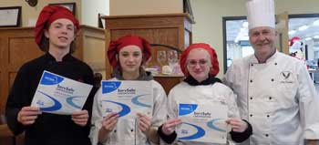 Joshua Raught, Trinity Sneed, Lacey Gross holding their certificates standing next to Chef Farmelo ServSafe Proctor Instructor.