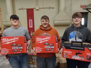 three students holding tool kits