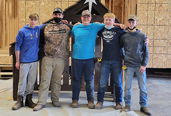 Five students in the garage posing for a picture